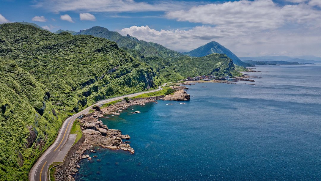 Fotograf Stefan Bogner fährt auf einer kurvenreichen Bergstraße in Taiwan, umgeben von üppiger, tropischer Landschaft