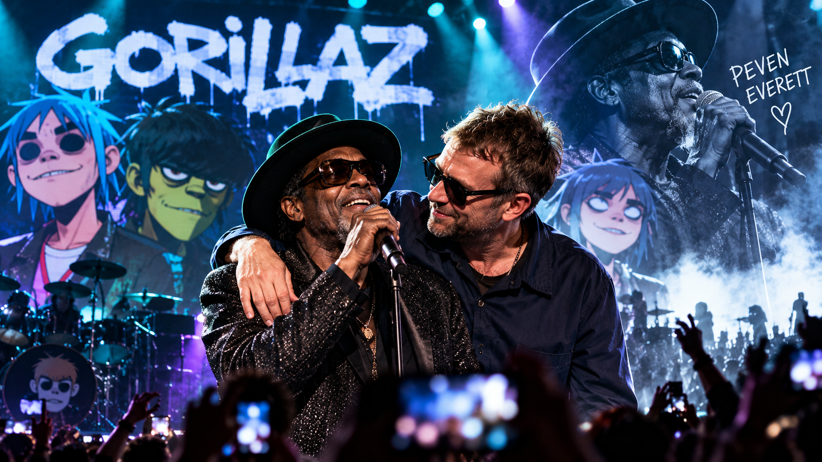 Peven Everett singt auf einer großen Konzertbühne ins Mikrofon, während Damon Albarn ihn freundschaftlich umarmt; im Hintergrund sind Gorillaz-Motive, Bühnenlichter und ein jubelndes Publikum zu sehen.